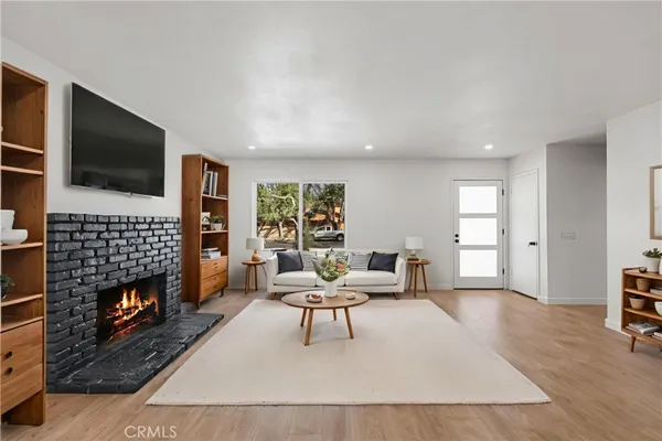 a living room with furniture a flat screen tv and a fireplace