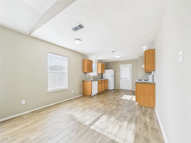 a view of a kitchen with furniture and wooden floor