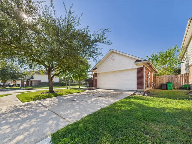 a view of a house with a big yard and large trees
