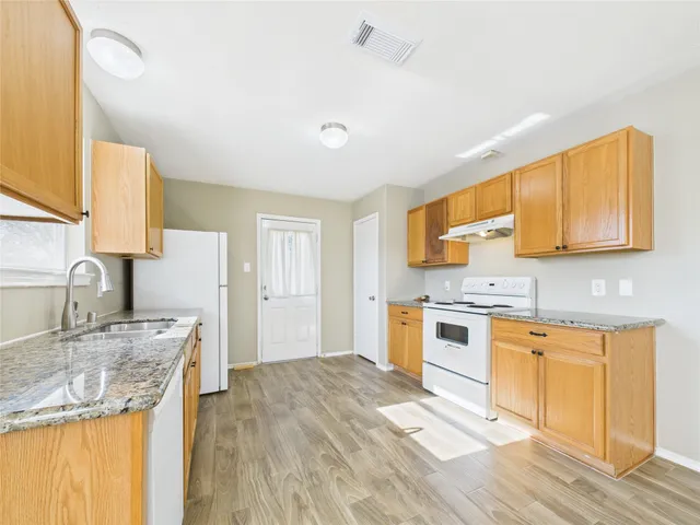 a kitchen with stainless steel appliances granite countertop a sink stove and refrigerator