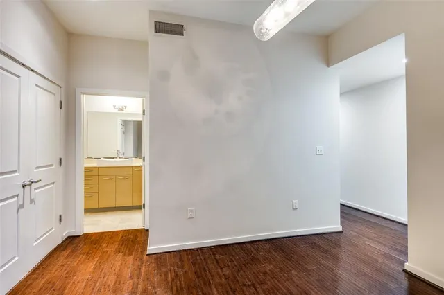 an empty room with wooden floor and cabinet