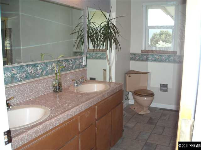 14215 Virginia Foothills Drive Reno, NV 89521 - Photo 5 of 12 a bathroom with a granite countertop sink and a toilet