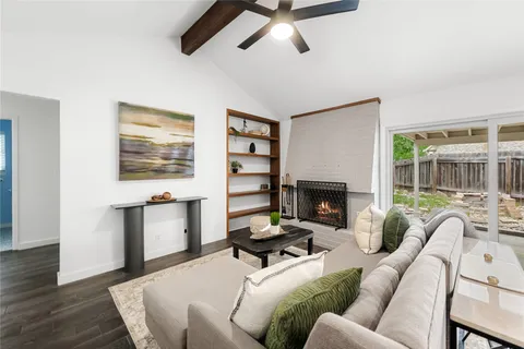 a living room with furniture a fireplace and a large window