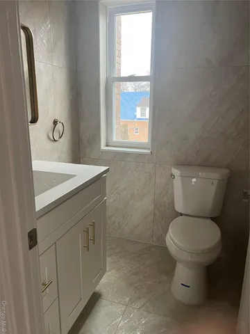 a bathroom with a granite countertop sink and a toilet