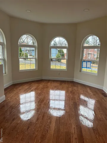 a kitchen with stainless steel appliances granite countertop a refrigerator a sink a stove and white cabinets with wooden floor