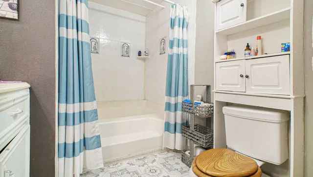 a bathroom with a toilet and a shower curtain