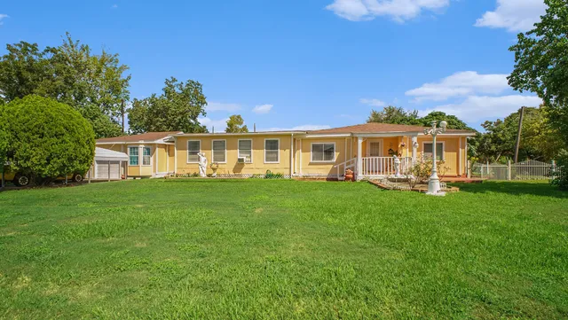 a view of a house with a yard table and chairs