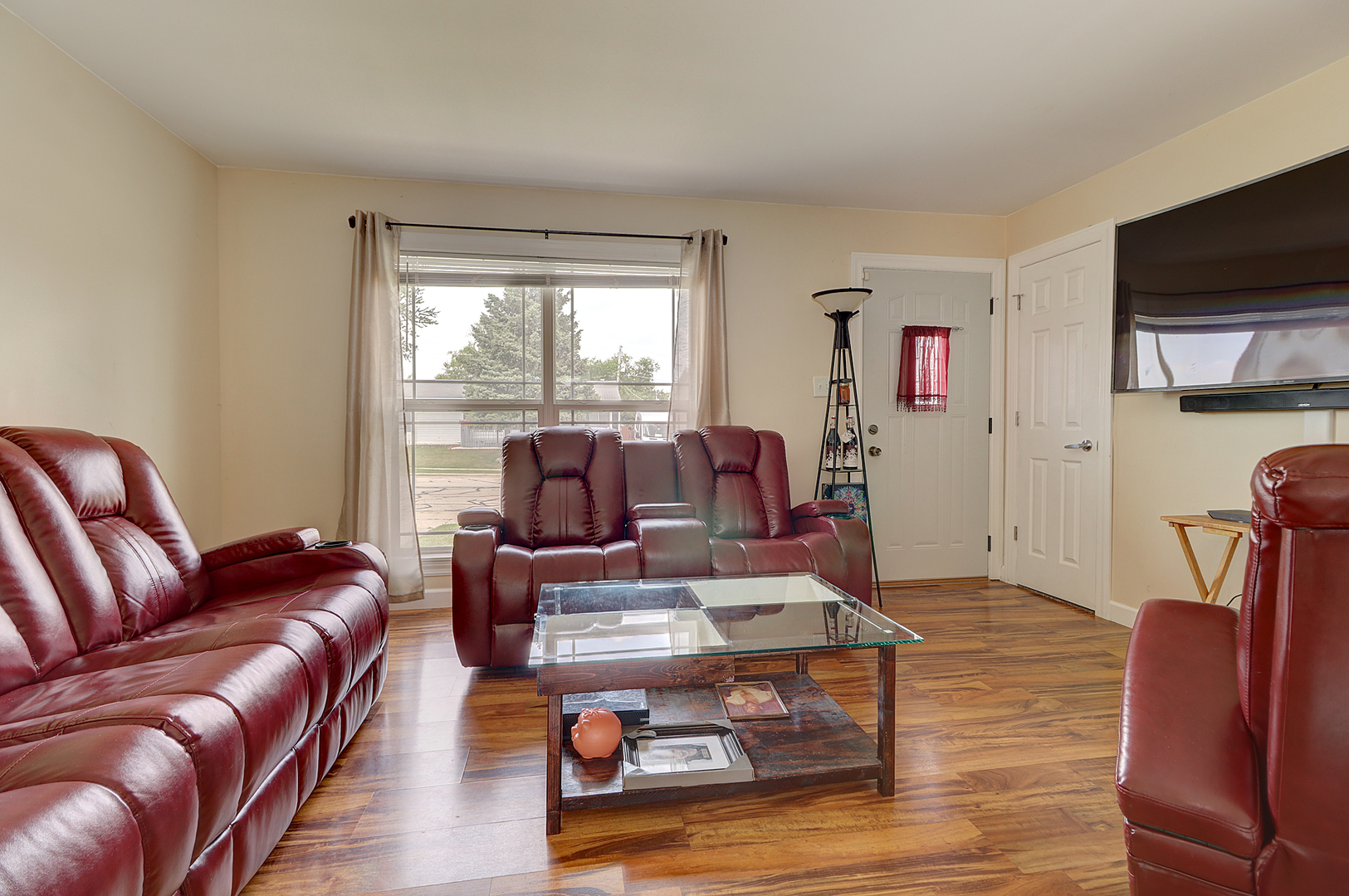 231 Murphy Drive Romeoville, IL 60446 - Photo 2 of 14 a living room with furniture a flat screen tv and a large window