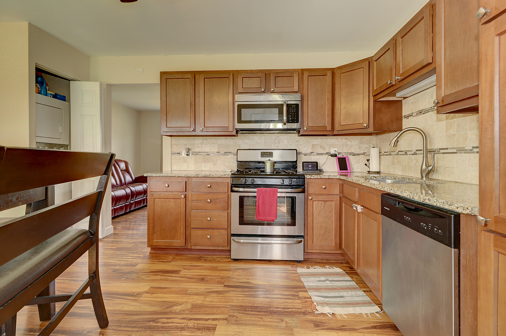 231 Murphy Drive Romeoville, IL 60446 - Photo 5 of 14 a kitchen with stainless steel appliances kitchen island granite countertop a stove top oven a sink dishwasher and cabinets with wooden floor