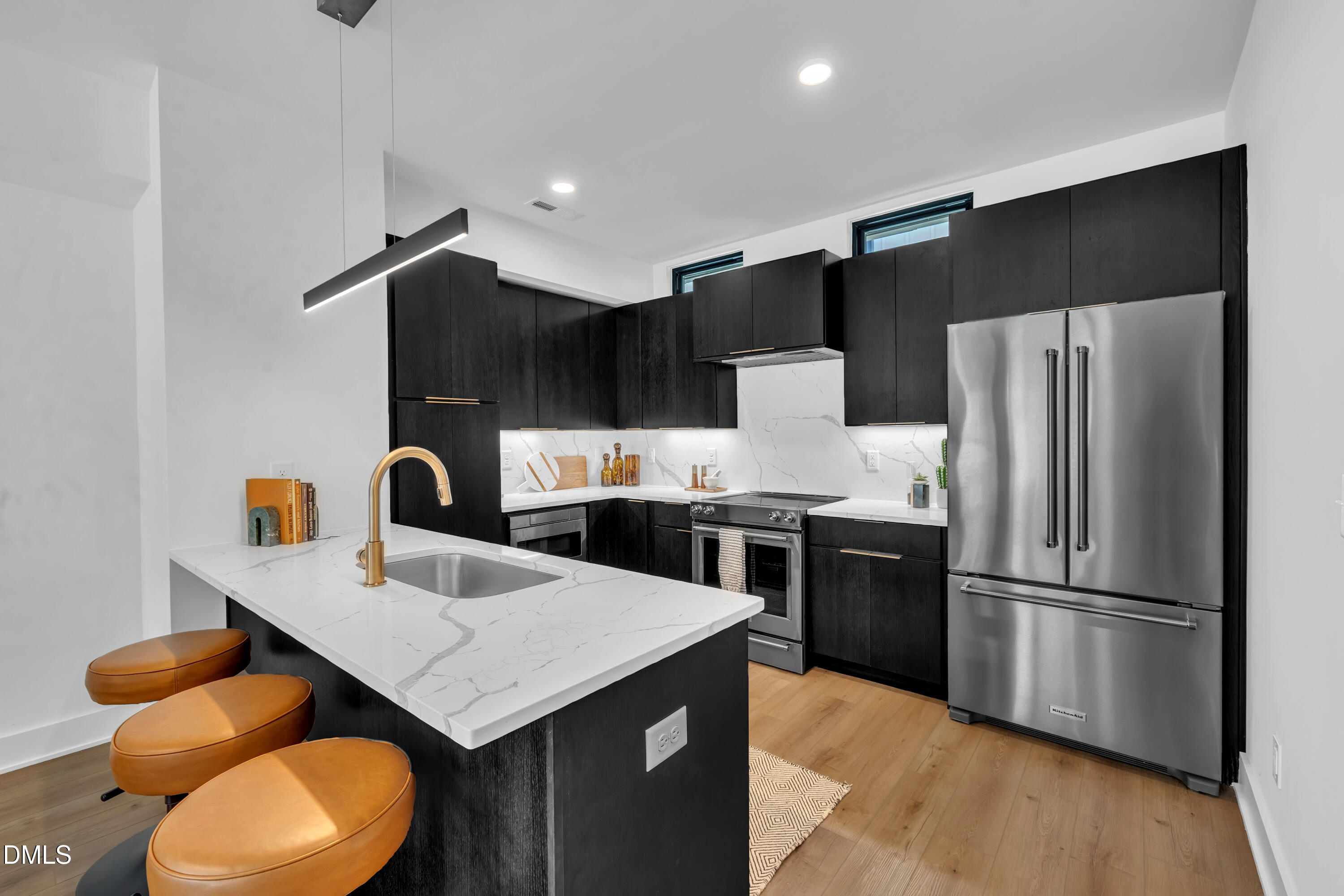 512 Gordon Street, Unit 305 Durham, NC 27701 - Photo 10 of 38 a kitchen with stainless steel appliances granite countertop a refrigerator a sink dishwasher with a dining table and chairs
