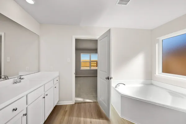 a spacious bathroom with a bathtub sink and mirror