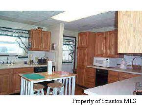 1508 Spring Hill Road Sterling, PA 18463 - Photo 3 of 6 a kitchen with kitchen island a sink table and chairs