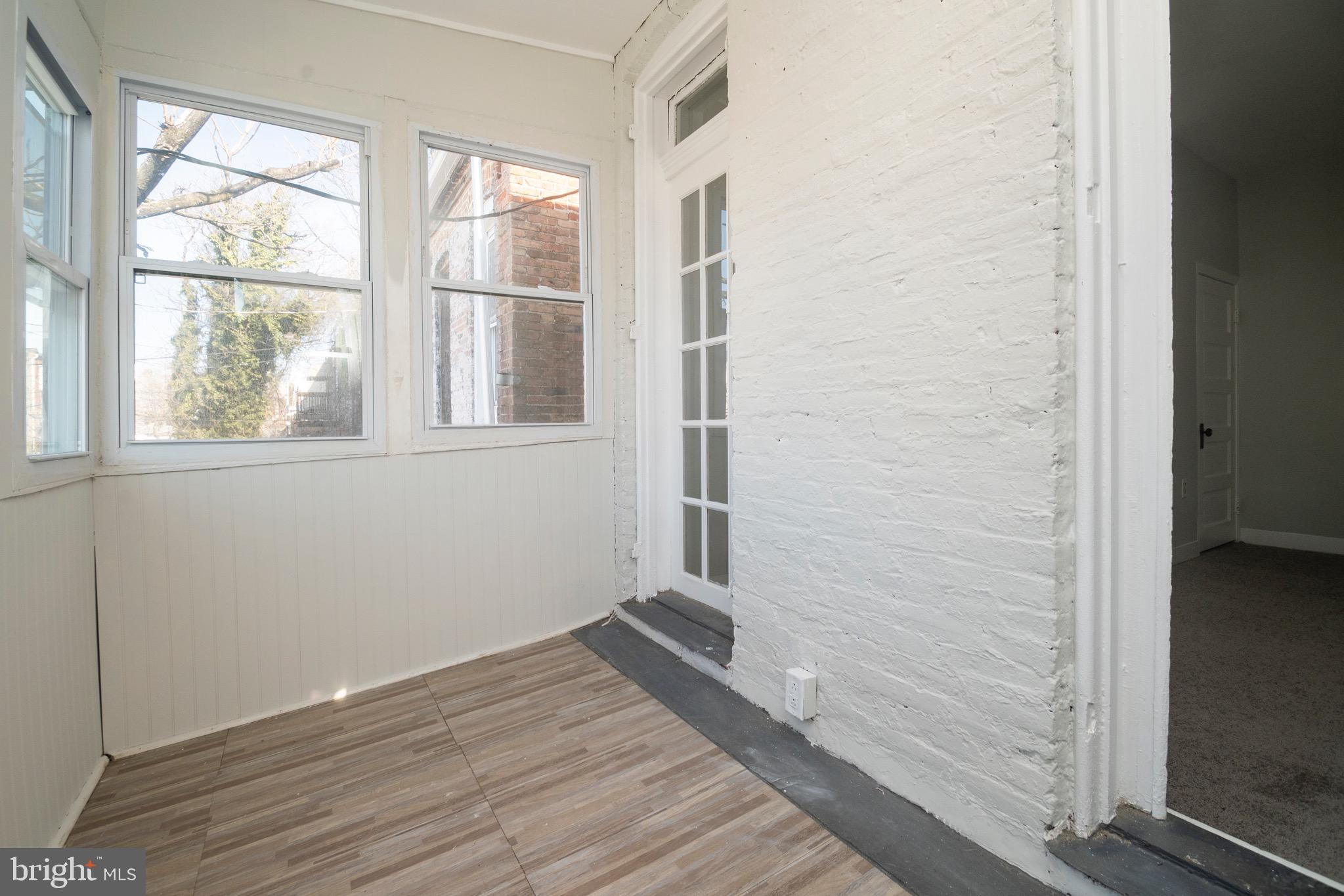 1626 Appleton Street Baltimore, MD 21217 - Photo 12 of 22 an empty room with wooden floor and windows