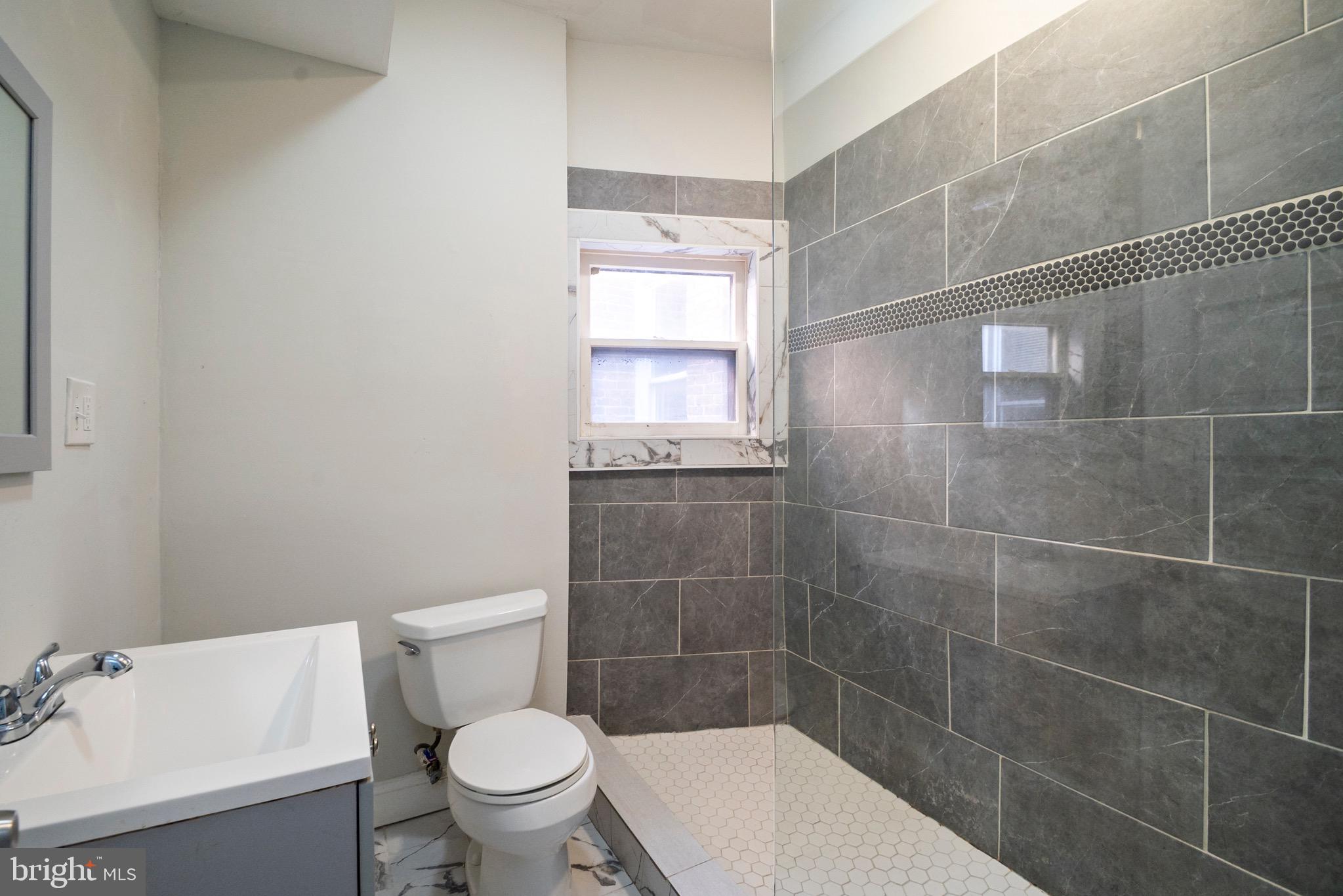 1626 Appleton Street Baltimore, MD 21217 - Photo 20 of 22 a bathroom with a toilet a sink and a shower