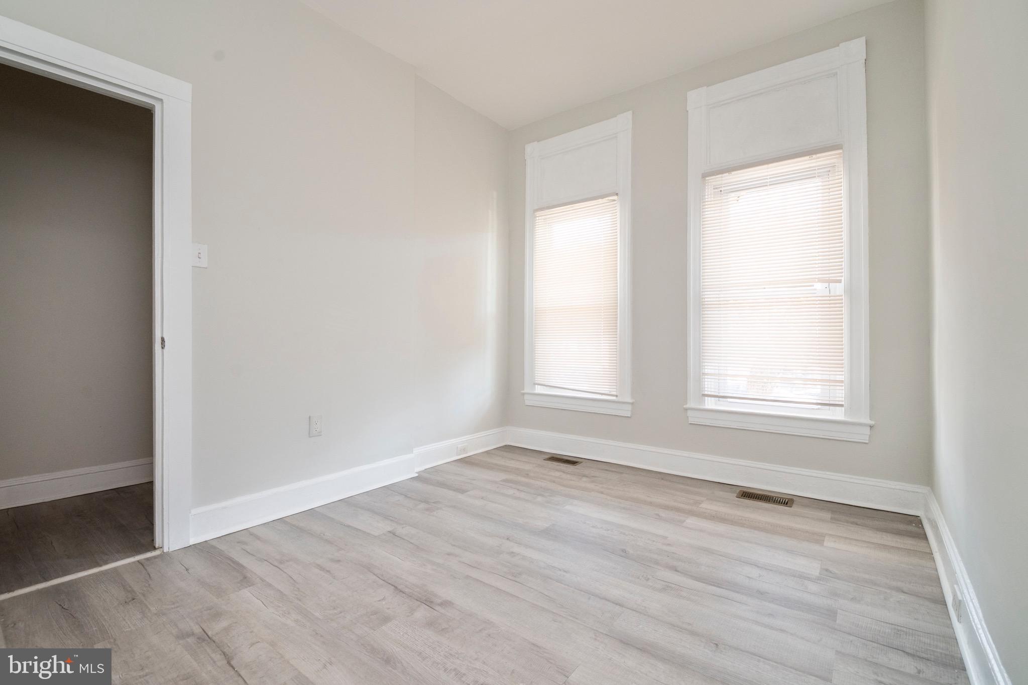 1626 Appleton Street Baltimore, MD 21217 - Photo 3 of 22 an empty room with wooden floor and windows