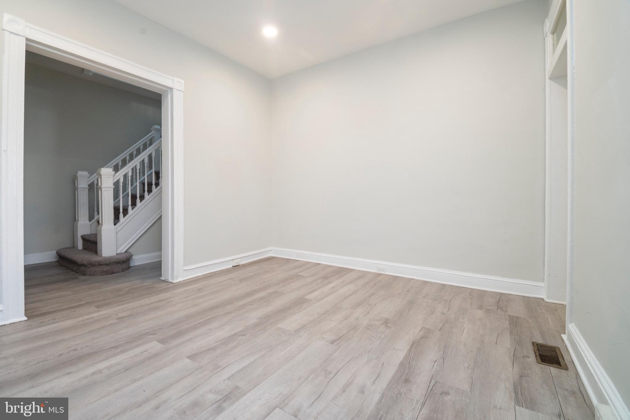 1626 Appleton Street Baltimore, MD 21217 - Photo 6 of 22 a view of an empty room with wooden floor and a window