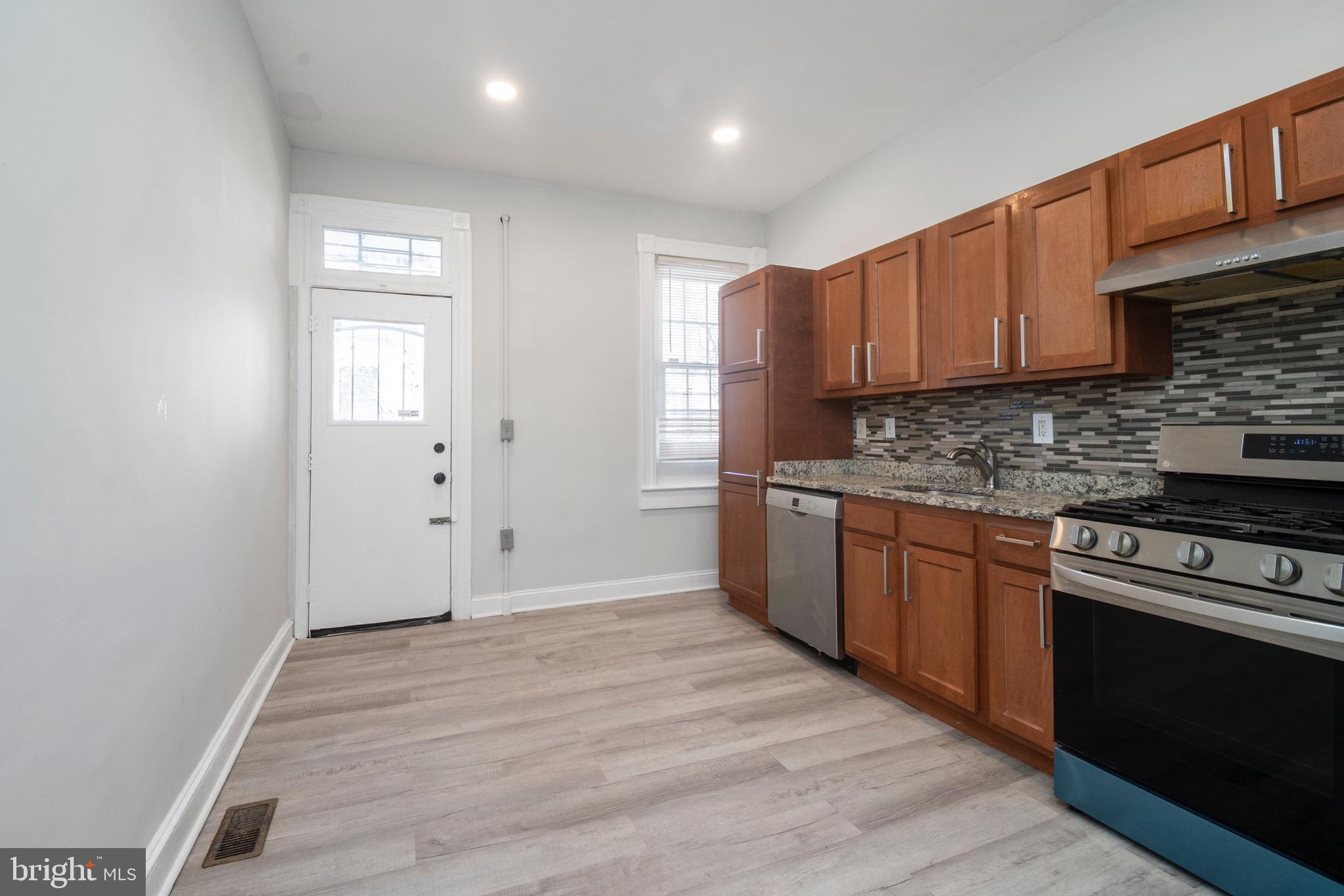 1626 Appleton Street Baltimore, MD 21217 - Photo 9 of 22 a kitchen with stainless steel appliances granite countertop a stove a sink and a refrigerator