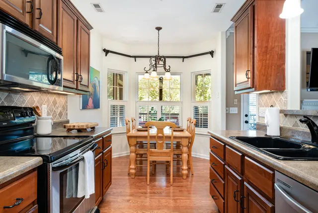 a kitchen with stainless steel appliances granite countertop a stove a sink and a microwave