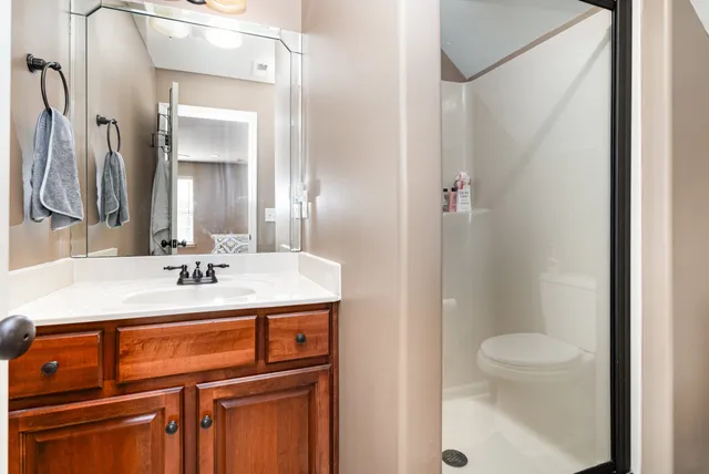 a bathroom with a sink a toilet and shower