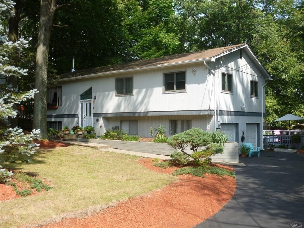 a front view of a house with a yard and a garden