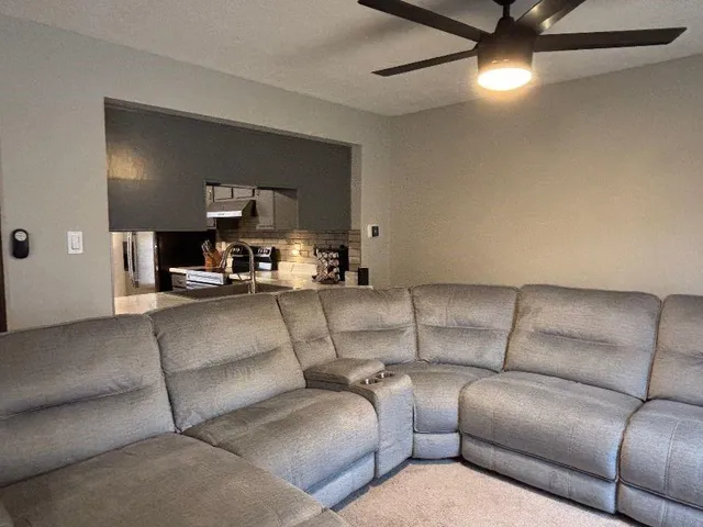 a living room with a couch and a ceiling fan