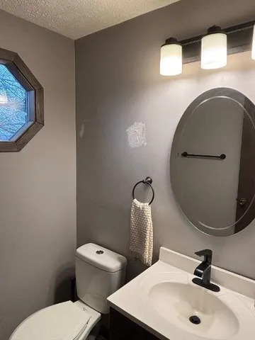 a bathroom with a toilet sink and mirror