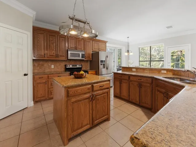 a kitchen with stainless steel appliances granite countertop a sink a stove top oven a counter space and cabinets