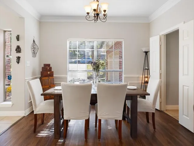 a dining room with furniture a chandelier and wooden floor