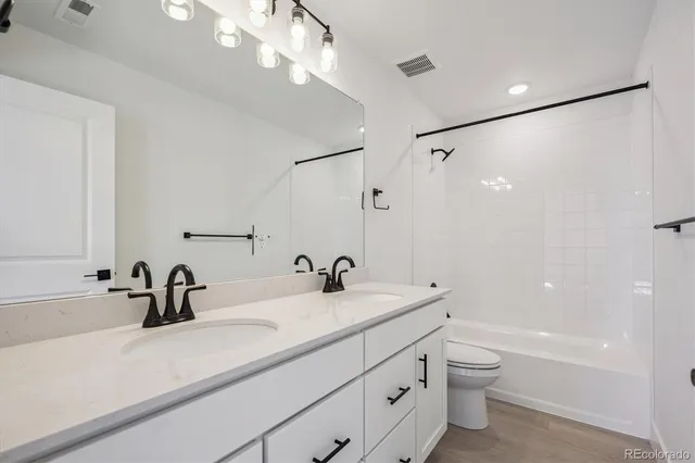 a bathroom with a sink a toilet and a large mirror