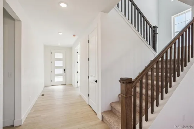 a view of a hallway with wooden floor and staircase