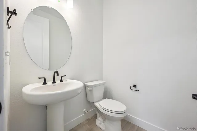 a bathroom with a sink a toilet and a mirror