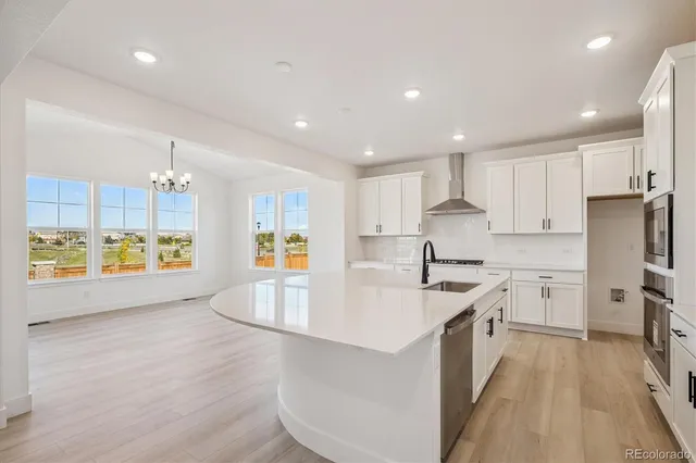 a large kitchen with stainless steel appliances granite countertop a lot of counter space and wooden floor