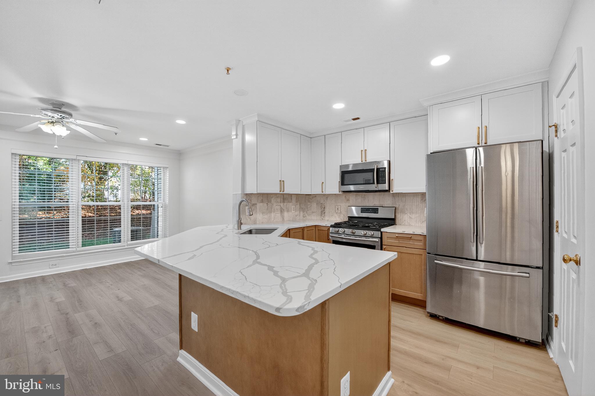 46932 Courtyard Square Sterling, VA 20164 - Photo 1 of 15 a kitchen with a refrigerator a microwave oven a stove and a sink with wooden floor