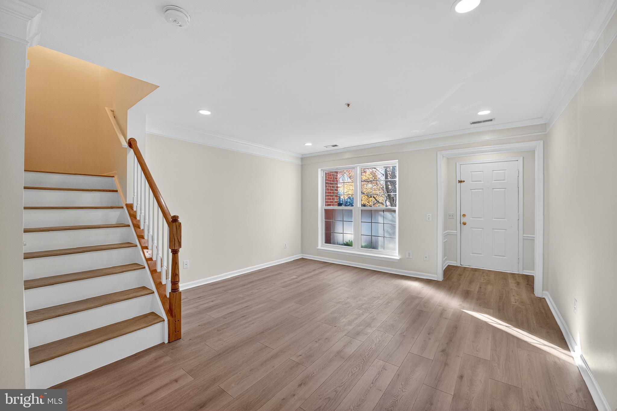 46932 Courtyard Square Sterling, VA 20164 - Photo 4 of 15 a view of an empty room with wooden floor and stairs