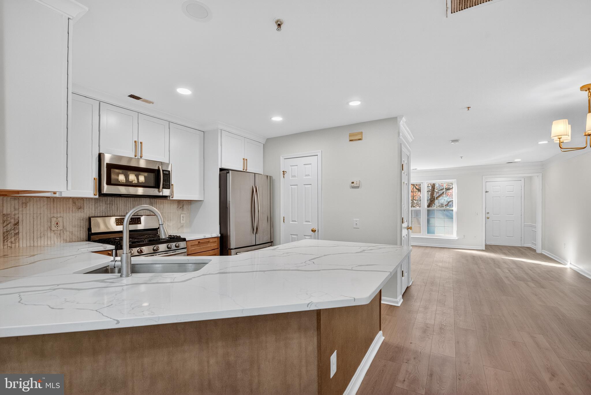 46932 Courtyard Square Sterling, VA 20164 - Photo 5 of 15 a kitchen with stainless steel appliances a sink a microwave a refrigerator and cabinets
