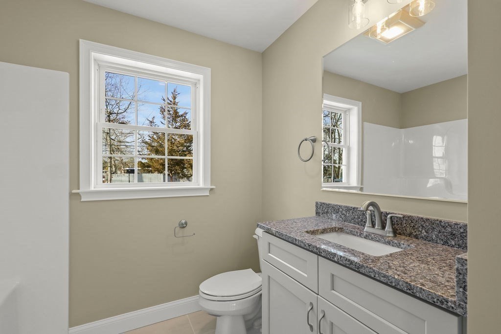 81 Maple Springs Road Wareham, MA 02571 - Photo 8 of 17 a bathroom with a granite countertop sink a toilet and a mirror