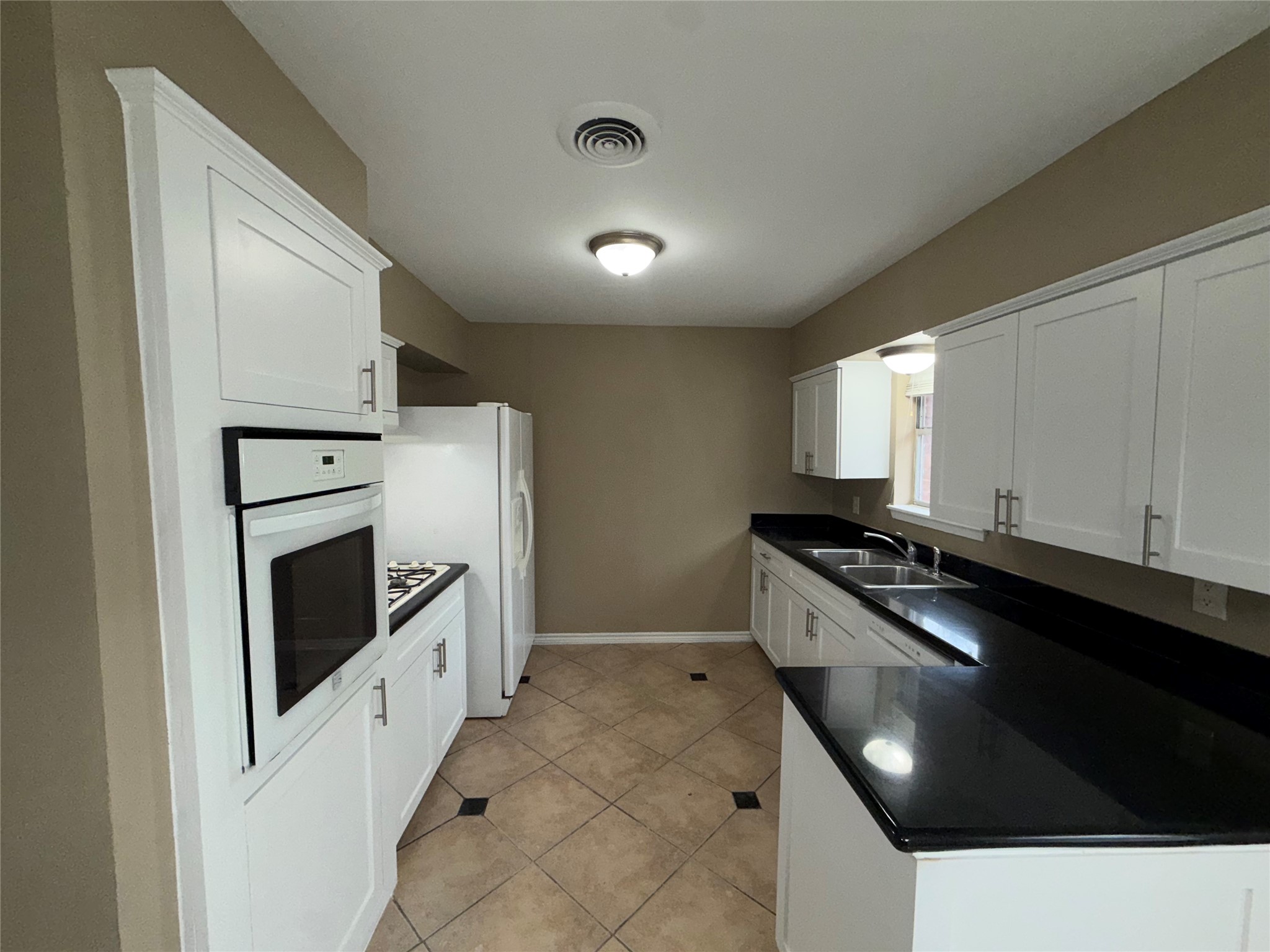 7306 Troulon Drive Houston, TX 77074 - Photo 7 of 16 a kitchen with granite countertop white cabinets and white appliances