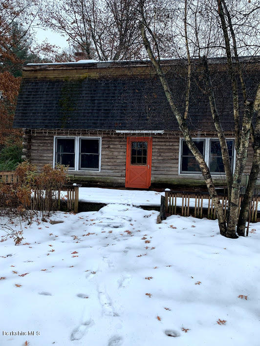a front view of house with yard covered in snow