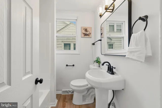 a bathroom with a sink a toilet and a mirror