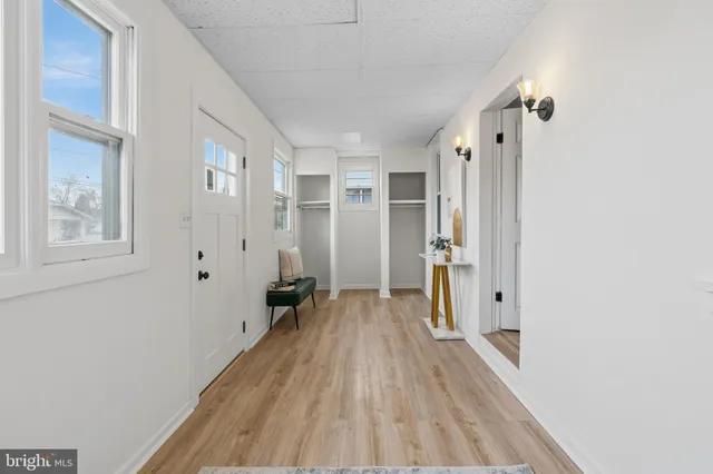 a view of a hallway with wooden floor and closet