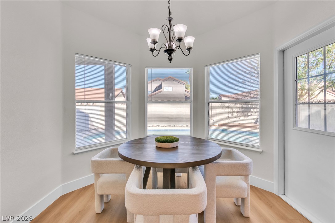 370 Rushing Creek Court Henderson, NV 89014 - Photo 21 of 32 Sunlight streams through triple bay windows onto warm wood-plank flooring in this cozy dining nook.