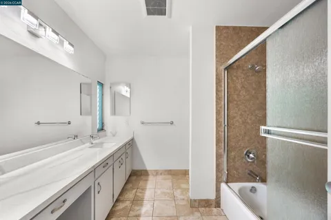 a spacious bathroom with a tub sink and mirror