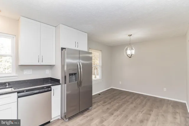 a kitchen with stainless steel appliances a refrigerator and a stove top oven