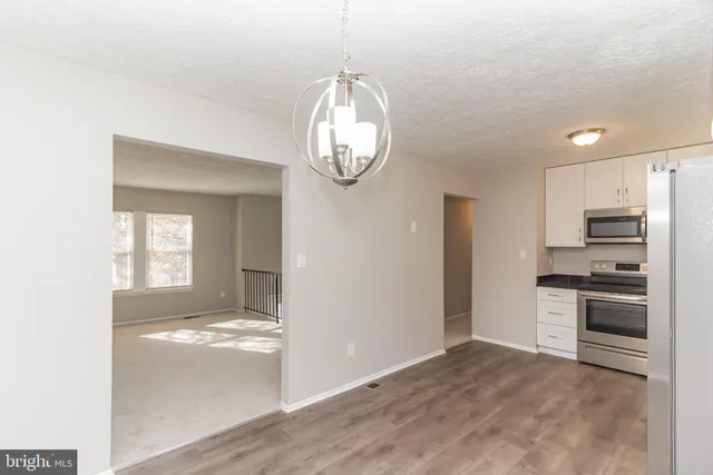 a view of a kitchen with a sink and dishwasher a refrigerator with wooden floor