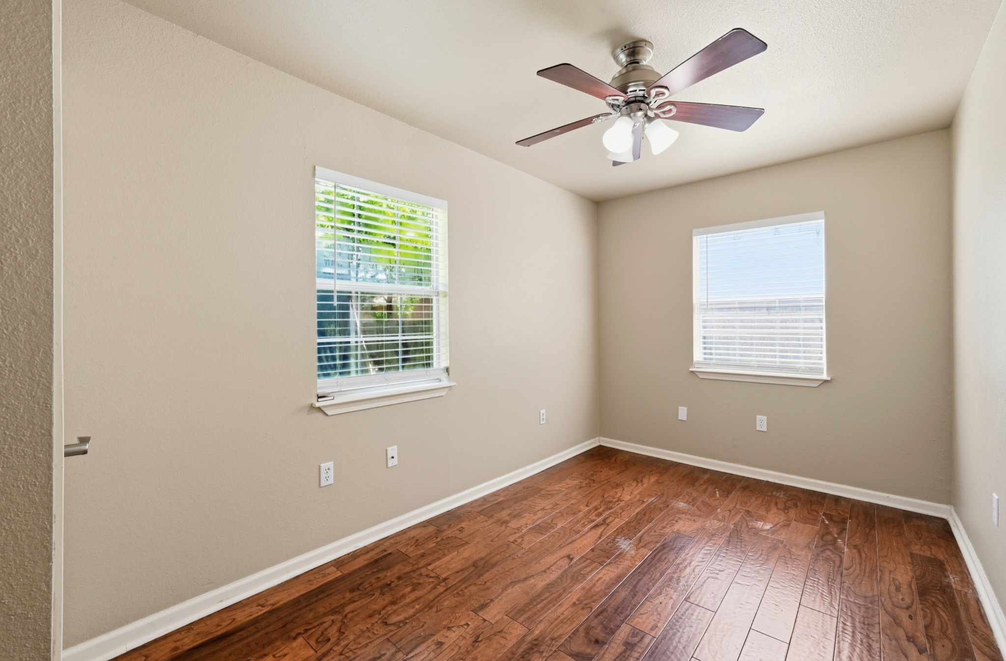 1127 Parr Street Luling, TX 78648 - Photo 12 of 20 Rich hardwood floors complement two bright windows in this inviting, comfortable bedroom.