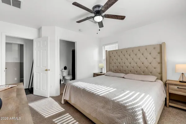 a bedroom with a large bed and a chandelier