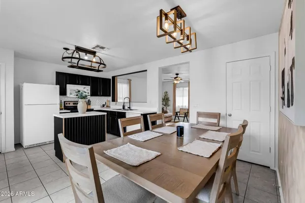 a view of kitchen with stainless steel appliances granite countertop dining table and chairs