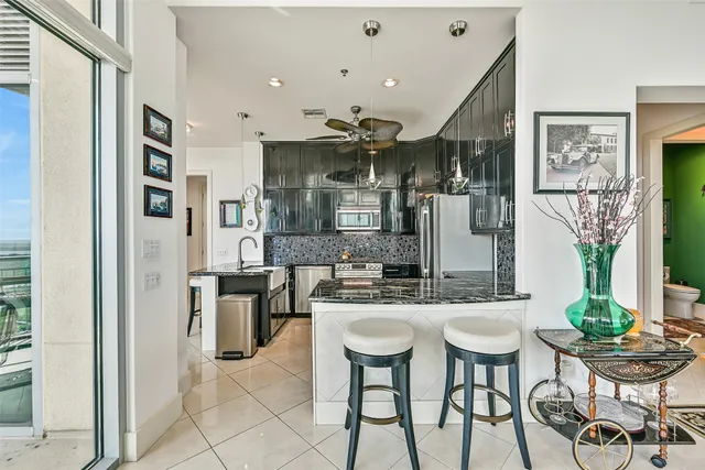 a kitchen with stainless steel appliances kitchen island granite countertop a dining table and chairs