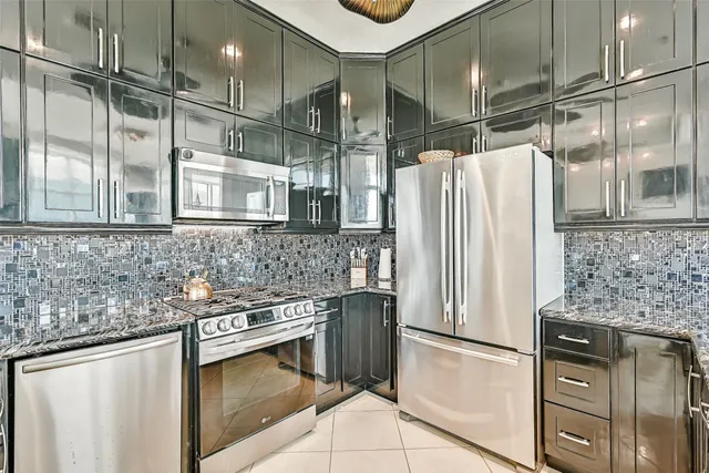 a kitchen with stainless steel appliances granite countertop a refrigerator and a sink