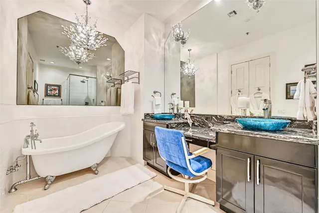 a spacious bathroom with a granite countertop tub a sink and mirror